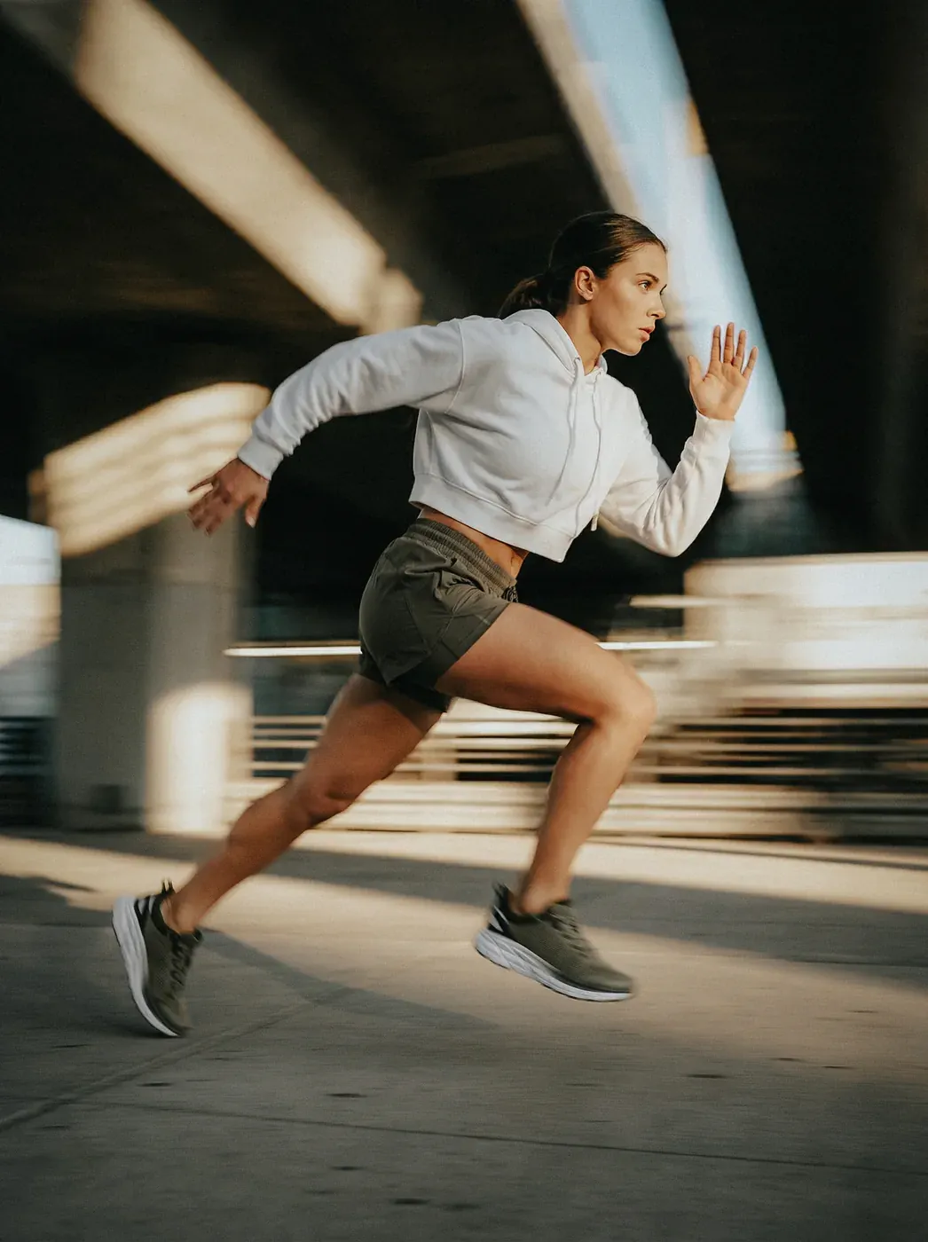 Éditorial running urbain femme en course sous autopont, sneaker kaki campagne 100% IA — Trendy Colors